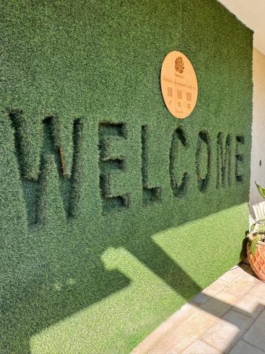 a green wall with a sign that reads welcome abroad at פרדייז ברמה in Had Nes