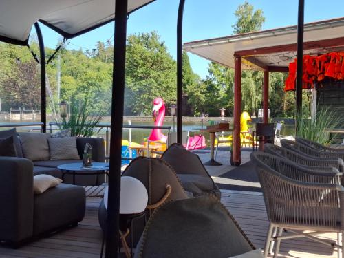a patio with couches and chairs on a deck at Ferienwohnung Sweety Haus Sachsensteinblick in Bad Sachsa