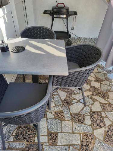 a table and chairs on a floor with a tile floor at Apartmani i sobe Mara in Rab