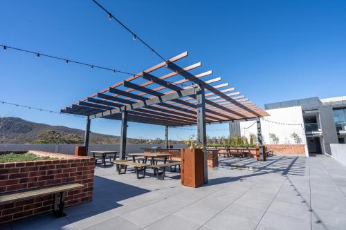 a pavilion with tables and benches on a patio at Rooftop patio w Mt View, Parking, Wifi n Netflix in Braddon