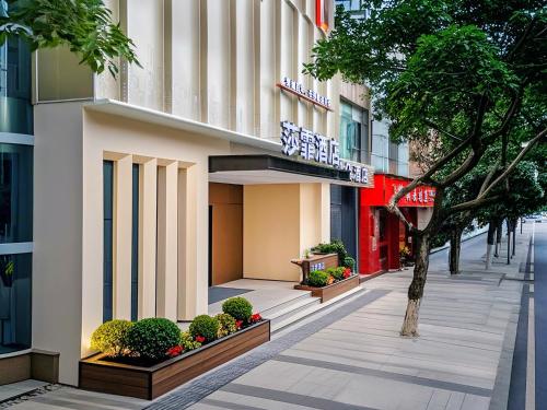 a sidewalk in front of a building with a tree at 重庆莎霏酒店大渡口店 in Chongqing