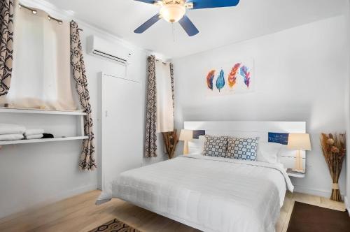 a white bedroom with a bed and a ceiling fan at Oceanfront Bungalow Cable Beach 2 Bedroom in Macbride