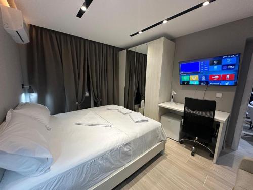 a bedroom with a bed and a desk and a television at Ionian rooms in Vlorë