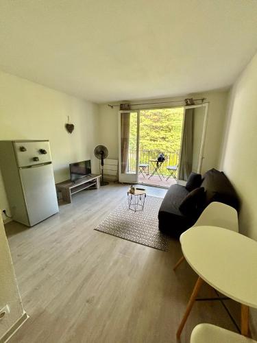 - un salon avec un canapé et un réfrigérateur dans l'établissement Appartement Les Aigues Marine, aux Lecques