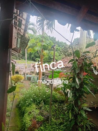 a sign for a hotel in a garden at Eco lodge finca magdalena in Altagracia