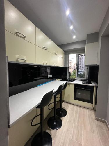 a kitchen with a counter and two stools at Ionian rooms in Vlorë