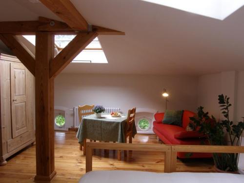 a living room with a table and a red couch at Herrenhaus Libnow in Murchin