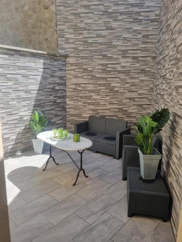 a patio with a table and chairs and a brick wall at PARIS 20 min ORLY Aeroport 10 min Maison Paradis vert in Villeneuve-le-Roi