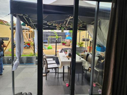 a patio with a table and chairs under a tent at Tomorrowland rooms in Rumst
