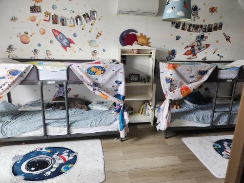 a bedroom with two bunk beds and a wall with planets at Tomorrowland rooms in Rumst