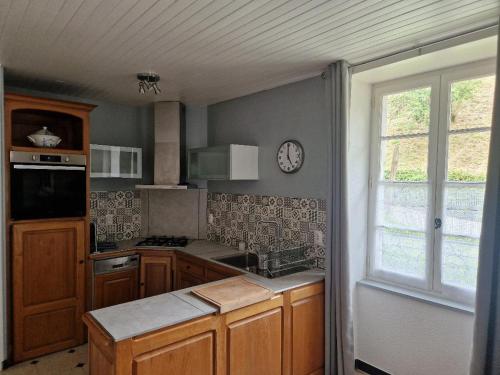 a kitchen with a sink and a clock on the wall at Domaine Garmidou in Lucq-de-Béarn