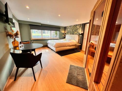 Un dormitorio con una cama, una mesa y una silla. en Studio with sauna, en Meise