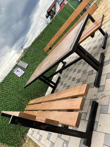 a wooden bench sitting on top of a lawn at Bella LUX in Modriča