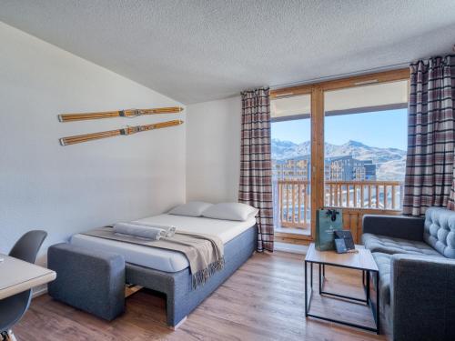 a bedroom with a bed and a couch and a window at Val Thorens : Appart moderne 6 pers, accès pistes, parking, WIFI - FR-1-640-78 in Val Thorens