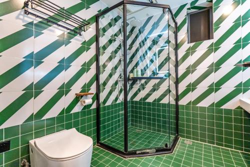 a green and white bathroom with a toilet at Misty Nest High Altitude River View B&B Hongyadong Branch in Chongqing