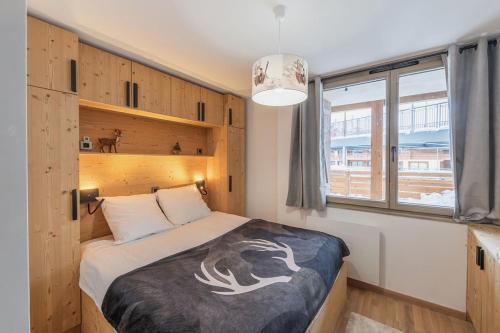 a bedroom with a bed and a large window at Alpe d'Huez Houses - Chez J et J - Quartz - 1 chambre ski au pied via Alpe Express in L'Alpe-d'Huez