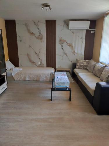 a living room with a couch and a table at Апартамент Родопи in Smolyan