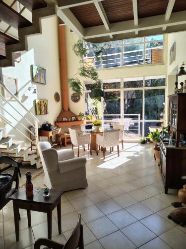 a living room with white furniture and a large window at Casa em Condominio Central in Campinas