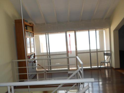 a room with a bed and a large window at LOFT en Condominio Central in Campinas