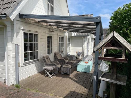 a deck with chairs and a grill on a house at Vrijstaande luxe Finse blokhut 2-6 pers in Kropswolde