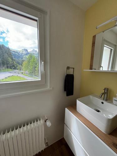 a bathroom with a sink and a window at Cozy appartement style chalet in Torgon