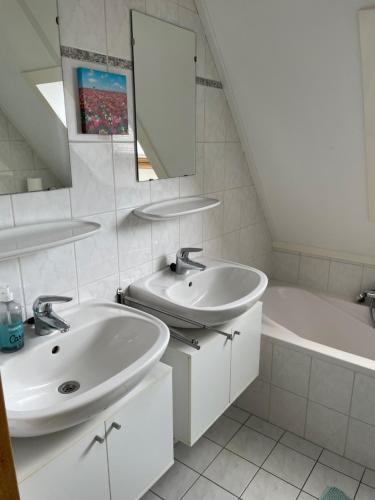 a bathroom with two sinks and a tub and a mirror at Vrijstaande luxe Finse blokhut 2-6 pers in Kropswolde