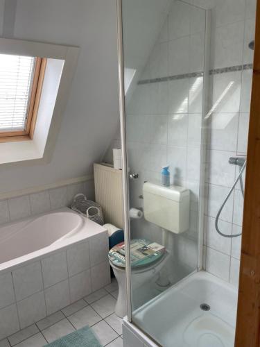 a bathroom with a tub and a toilet and a shower at Vrijstaande luxe Finse blokhut 2-6 pers in Kropswolde