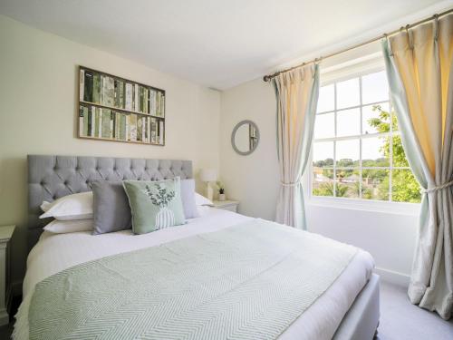 a bedroom with a large bed and a window at Polmear Farm Manor House in Charlestown