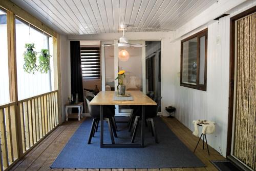 a room with a table and chairs on a balcony at Ruim en sfeervol chalet aan de rand van het bos in IJhorst