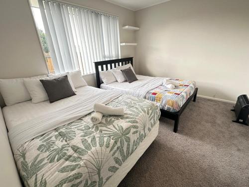 a bedroom with two beds and a window at Stunning Sea View Home Very near to AKL Airport in Auckland
