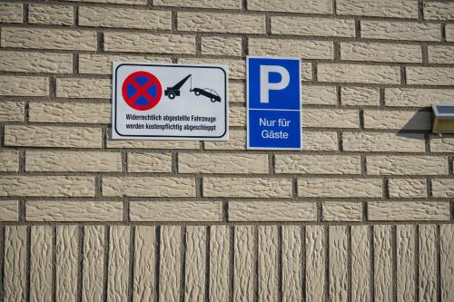 a sign on a brick wall with a parking sign at InterPension in Garbsen