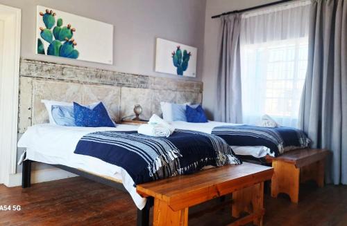 two beds in a bedroom with blue and white at Von Loë Huizen in Fauresmith