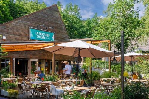 a restaurant with tables and chairs and an umbrella at De Oranje Kabouter in Durbuy