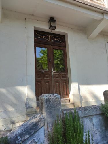 a wooden door of a house with stairs and a window at Chambre Frêne in Cadéac