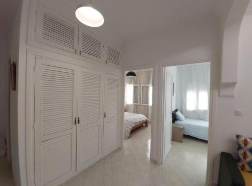 a white room with a bed and a closet at Miramar Beach Martil in Martil