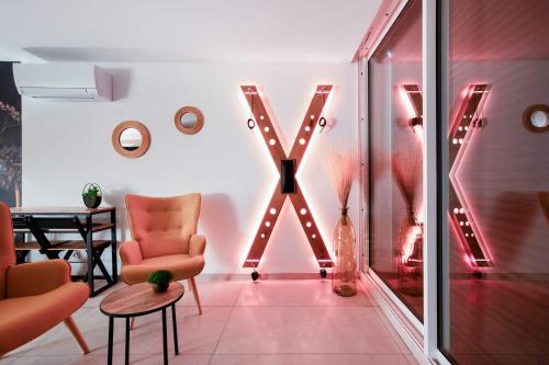 une pièce avec une grande lettre x sur le mur dans l'établissement ADDICT Heliopolis, au Cap d'Agde