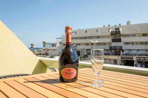 une bouteille de vin et un verre sur une table dans l'établissement ADDICT Heliopolis, au Cap d'Agde
