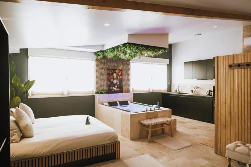 a bedroom with a large bed and a kitchen at Da Lisa wellness spa proche centre ville in Reims