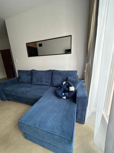 a blue couch in a living room with a mirror at Twoja Przystań SŁAWA- Apartament przy plaży in Sława
