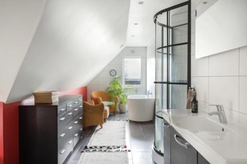 a bathroom with a tub and a sink and a bath tub at Poolvilla på Österlen in Brantevik