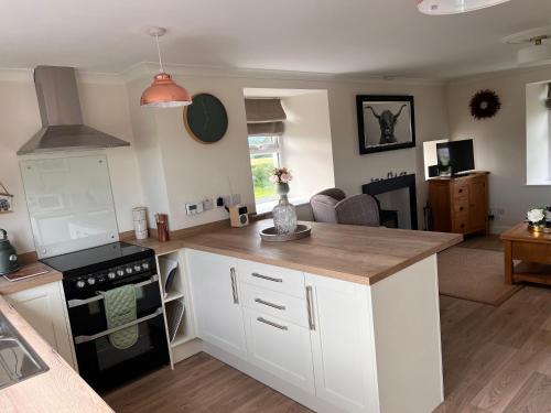 a kitchen with white cabinets and a counter top at Williamsfield Cottage in Holywood