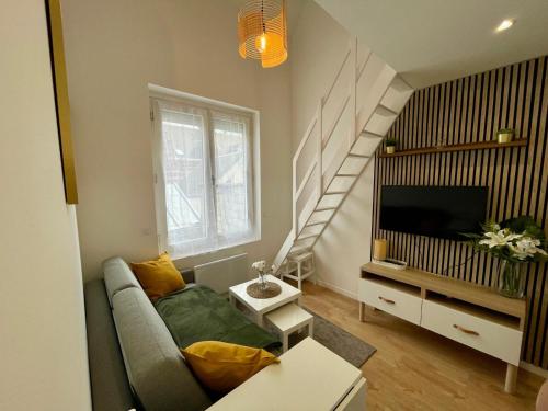 a living room with a couch and a staircase at Duplex cosy hyper centre in Amiens