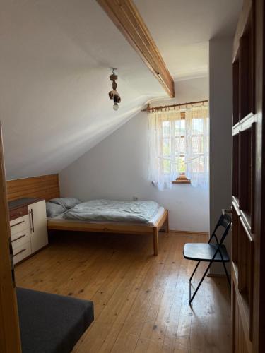 a bedroom with a bed and a chair in a room at Dom Letniskowy Sądecczyzna in Olszanka