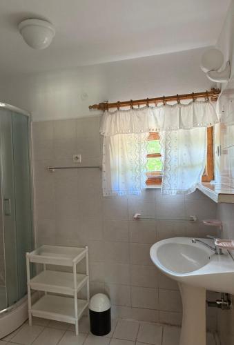 a white bathroom with a sink and a shower at Dom Letniskowy Sądecczyzna in Olszanka