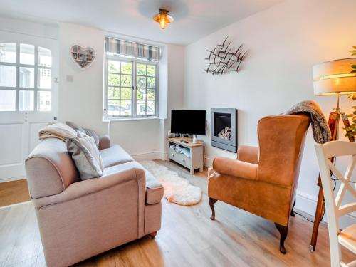 a living room with a couch and a chair at Daisy Cottage in Shaldon