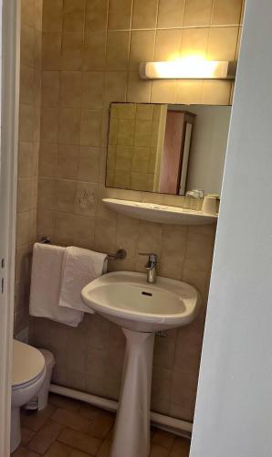 a bathroom with a sink and a mirror and a toilet at Hotel Paris Bercy in Paris