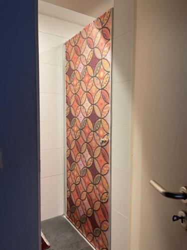 La salle de bains est pourvue d'une douche et d'un mur en mosaïque. dans l'établissement Peaceful oasis in Luxembourg center, à Luxembourg