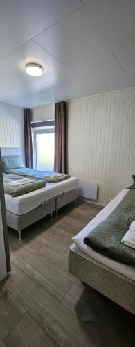 Un dormitorio con dos camas y una ventana. en Lakeside apartment, en Stryn