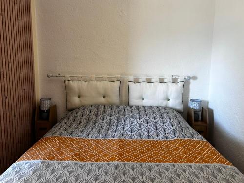 un lit avec une couette orange et grise dans une chambre dans l'établissement SOL Y MAR Location 4 personnes St Cyprien 2 étoiles FNAIM, à Saint-Cyprien