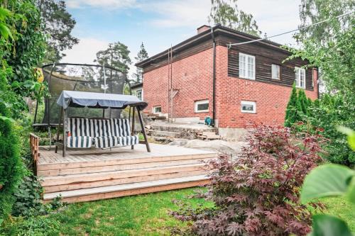 a wooden deck with a gazebo in a garden at Stylish Nordic Escape Near Stockholm in Huddinge